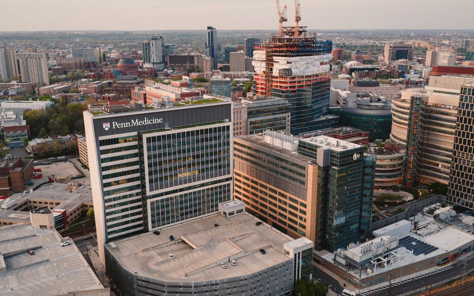 Aerial view of Penn Medicine buildings and a tower under construction in Philadelphia's skyline